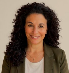 Rosella Hutchison's headshot. She is wearing a white shirt and an olive green blazer