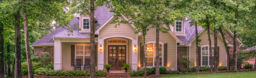 Luxury home encased in beautiful green trees. Simpson McCrady Protecting High-Net-Worth Assets in an Evolving Risk Landscape: 2025 Trends.