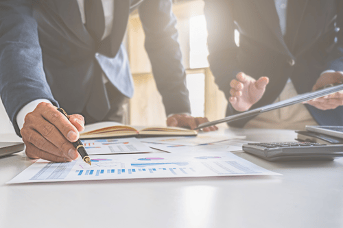 Two accountants overlooking a cash flow report on a table. Simpson McCrady Accountants’ Professional Liability Insurance.