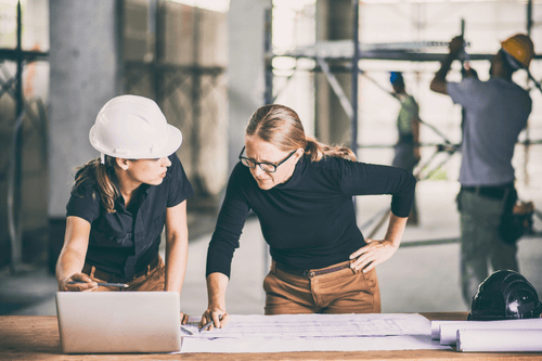 An architect and engineer reviewing a project drawing and schematic. Simpson McCrady Architects & Engineers’ Professional Liability Coverage.