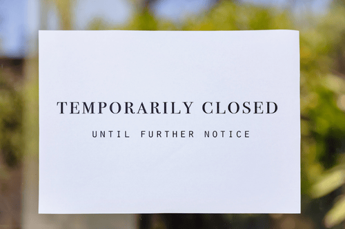 A signed on a glass door to a business that reads: Temporarily Closed Until Further Notice. Simpson McCrady Business Interruption Insurance.