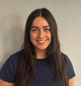 Samantha Palumbo headshot, dark hair, olive skin tone, wearing a navy blue shirt