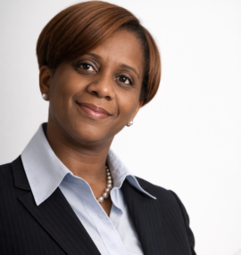 Lisa McGee headshot, she is wearing a blue blouse with a black jacket. White background