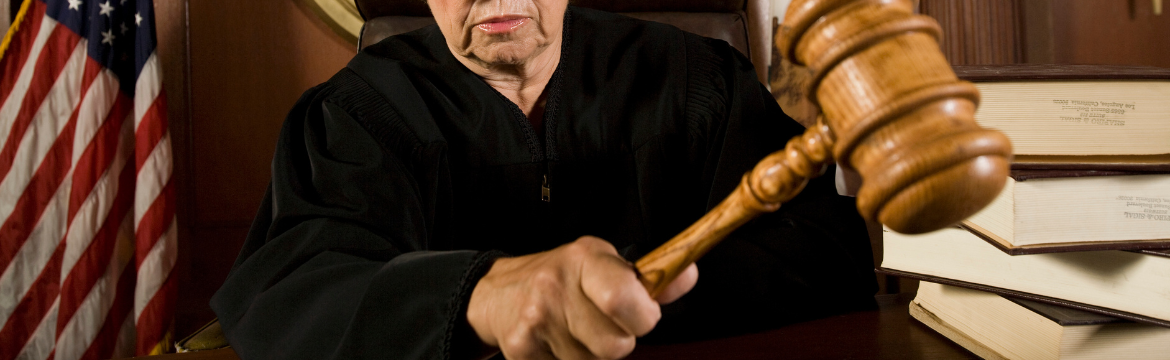 Partial Image of female judge knocking her gavel which is representative of  nuclear verdicts and the liability crisis in insurance. Simpson McCrady.