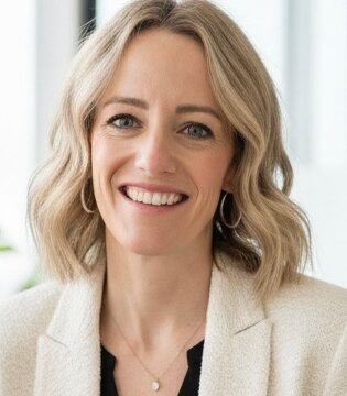 Jessica's headshot. Wearing a black blouse with a cream blazer.